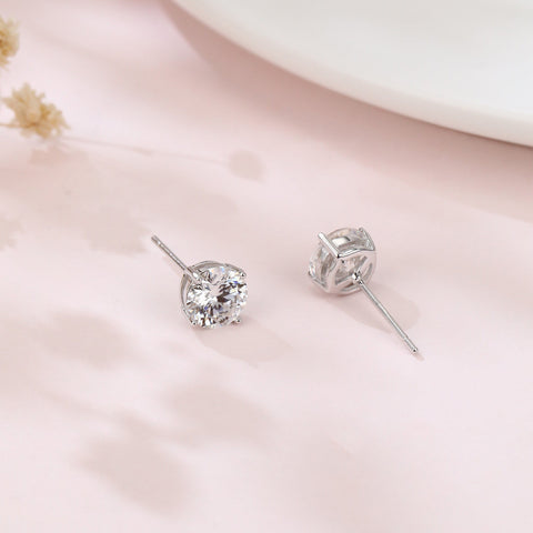 925 Sterling Silver Elegant Sparkling Moissanite Stud Earrings In Plated with White Gold On Blush Pink Backdrop