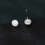 925 Sterling Silver Elegant Moissanite Halo Stud Earrings On Black Wood With Teal Background